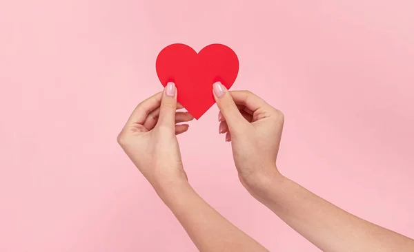 Vrouw met rood hart op roze achtergrond — Stockfoto