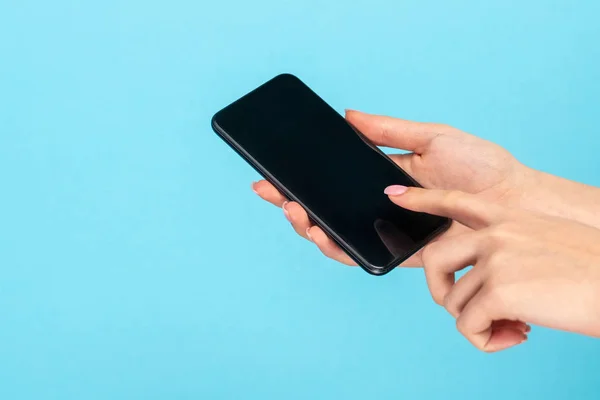 Girl using smartphone on blue background — Stock Photo, Image