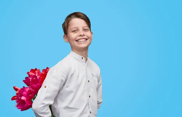 เด็กชายที่ยิ้มพร้อมดอกไม้เป็นของขวัญ — ภาพถ่ายสต็อก