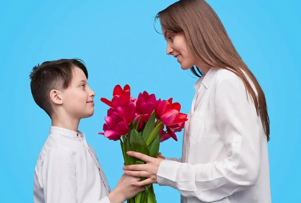 Menino apresentando flores para a mãe — Fotografia de Stock