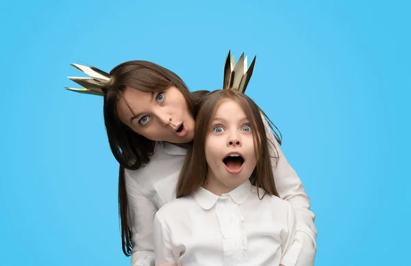Mujer juguetona y chica en coronas de papel — Foto de Stock