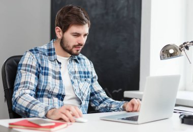 Ofiste dizüstü bilgisayarda çalışan sıradan bir adam. 