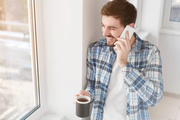 Веселий чоловік з кухольними балачками по телефону — стокове фото