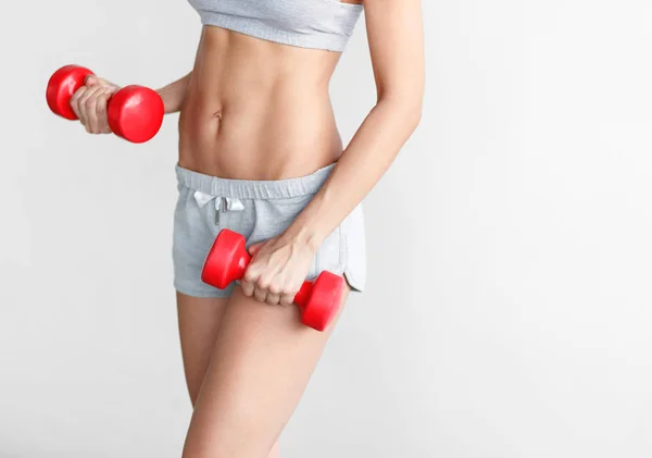 Mulher em forma de colheita fazendo exercício com halteres — Fotografia de Stock