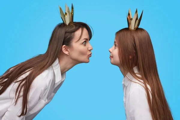 Playful girl and woman in crowns