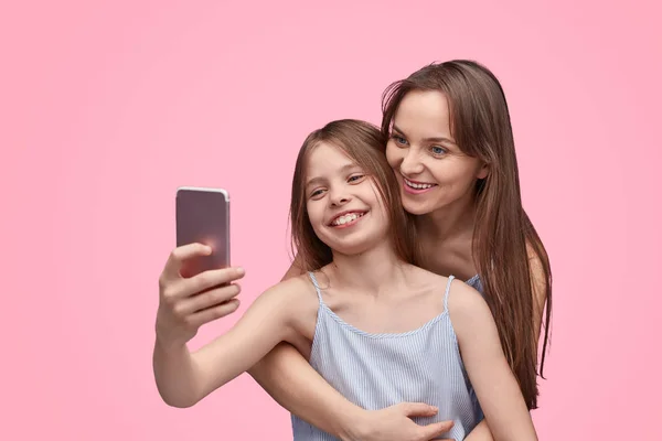 แม่และลูกสาวที่มีความสุขใช้สมาร์ทโฟน — ภาพถ่ายสต็อก