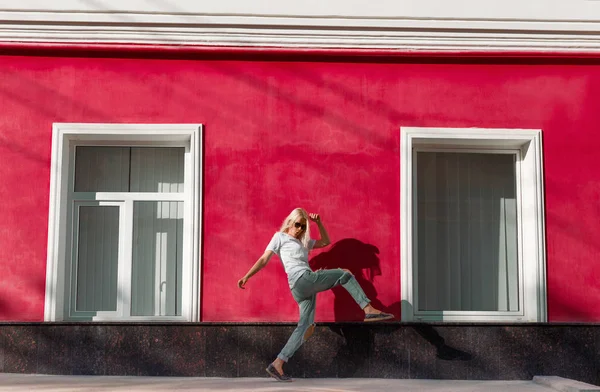 Rubia casual bailando bajo la luz del sol en la calle — Foto de Stock