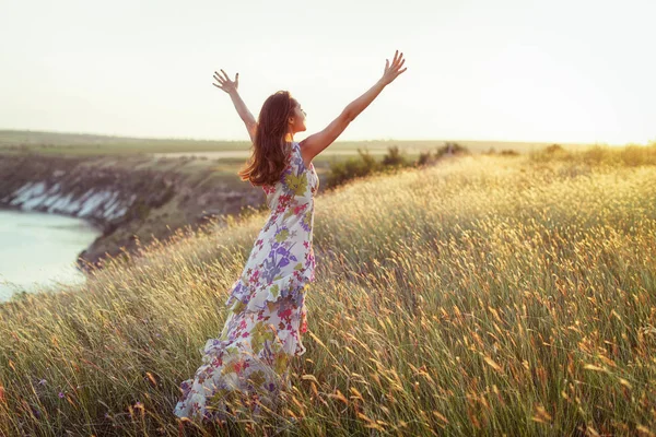 Glückliche Frau im hellen Kleid im Gras stehend — Stockfoto