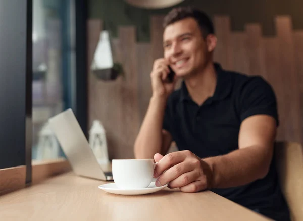 Człowiek w kawiarni drinka i mówiąc na telefon — Zdjęcie stockowe