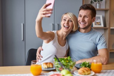 Yemek tadını çıkarırken mutlu çift alarak selfie 
