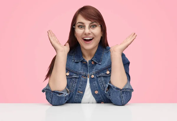 Amazed young woman sitting at table — Stock Photo, Image