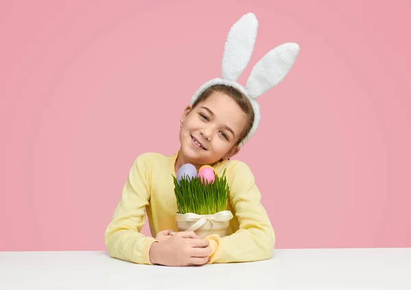 Gadis lucu dengan pot bunga rumput dan telur Paskah — Stok Foto