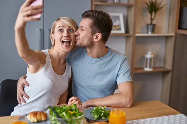 Romantic playful couple taking selfie at table — Stock Photo, Image