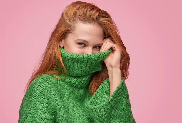 Entzückendes flirty Mädchen versteckt Gesicht im Pullover — Stockfoto