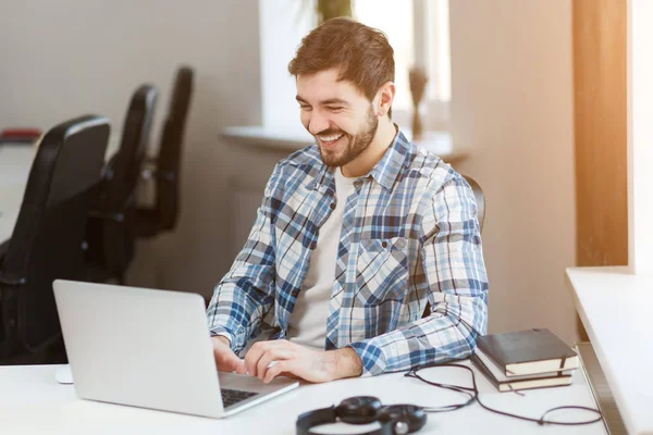 Щасливий чоловік використовує ноутбук за столом в офісі — стокове фото