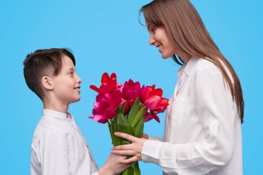 Gülümseyen çocuk annesine çiçek sunulması 