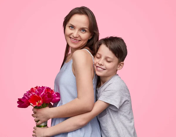 ลูกชายกอดและให้ดอกไม้กับแม่ — ภาพถ่ายสต็อก