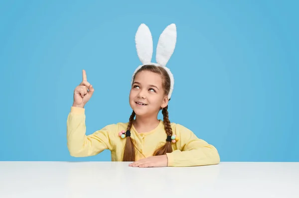 Chica con orejas de conejo apuntando hacia arriba — Foto de Stock