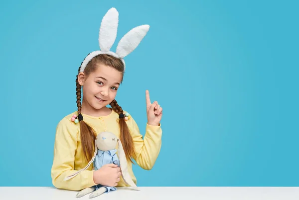 Gadis manis di telinga kelinci menunjuk ke atas — Stok Foto