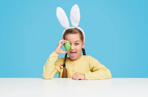 Chica juguetona en orejas de conejo posando con huevo de Pascua — Foto de Stock