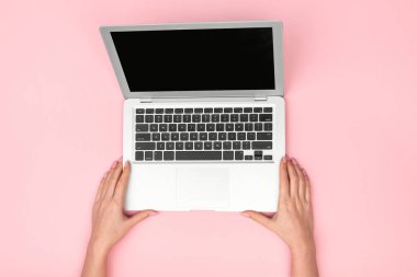Pembe zemin üstünde laptop ile eller