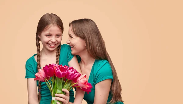 Mulher feliz e menina com um monte de flores — Fotografia de Stock