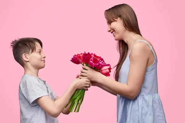 Wanita tertawa menerima buket bunga dari anak — Stok Foto