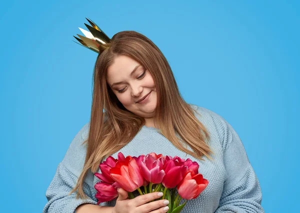 Plus size woman looking at red flowers