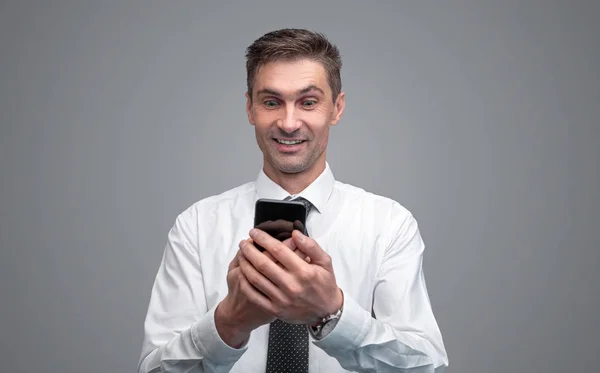 Surprised businessman using smartphone — Stock Photo, Image