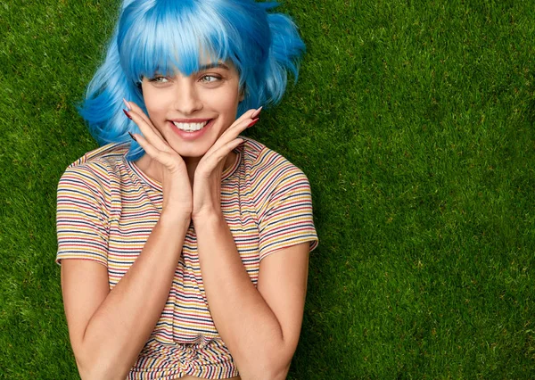 Mujer alegre con el pelo azul acostado en el césped — Foto de Stock