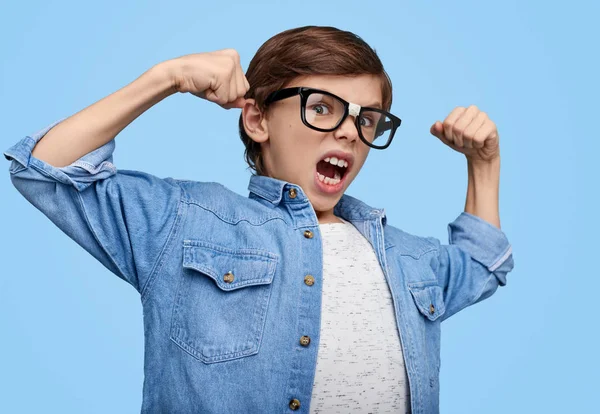 Expressive nerdy boy showing biceps — Stock Photo, Image