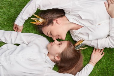 Sevgi dolu bir anne ve kızı çayır üzerinde yalan 