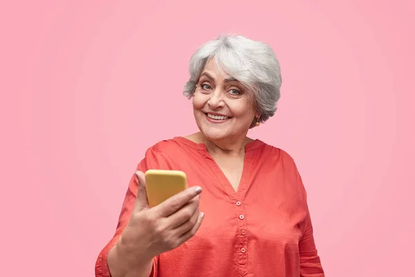 Excited elderly female with smartphone — Stock Photo, Image