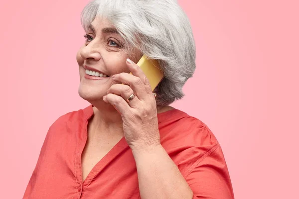 Smiling elderly woman talking on phone — Stock Photo, Image