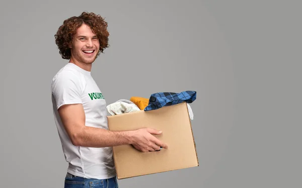Voluntario sonriente llevando donaciones — Foto de Stock