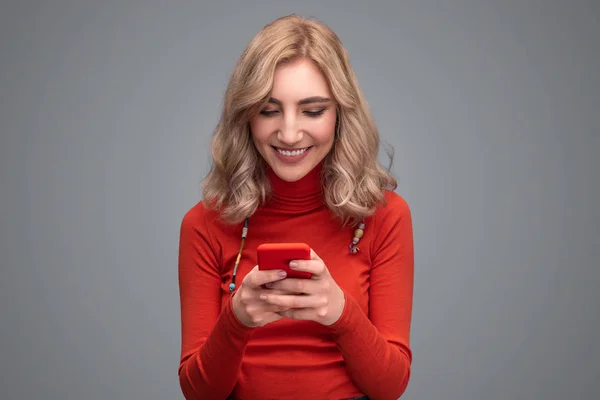 Sonriente señora navegando teléfono inteligente — Foto de Stock