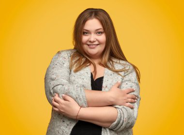 Artı boyutu kadın kendini kucaklayan