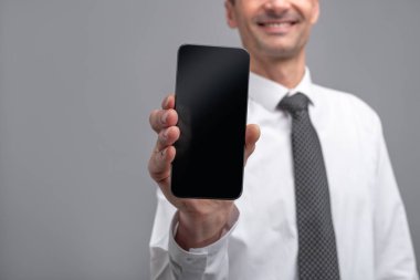 Smartphone gösteren kırpma işadamı