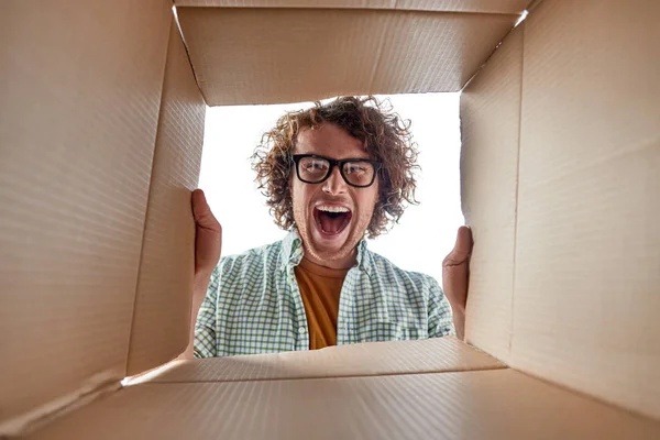 Hombre en gafas mirando dentro de la caja — Foto de Stock