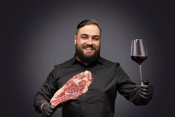 肉とワインを提供しているひげを生やしたシェフの笑顔 — ストック写真