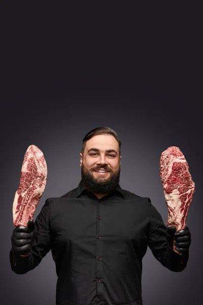 Дружелюбный человек, показывающий свежее мясо — стоковое фото