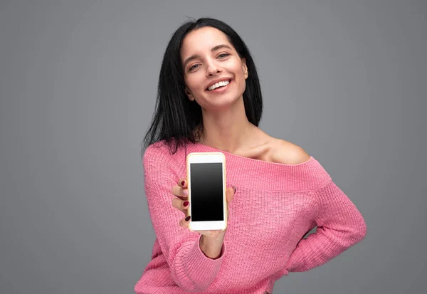 Веселая женщина демонстрирует современный смартфон — стоковое фото