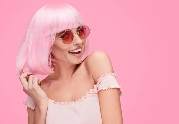 Mujer coqueta tocando el pelo rosa — Foto de Stock