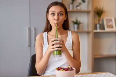 Kahvaltı için tatlı kız içme Yeşil Smoothie