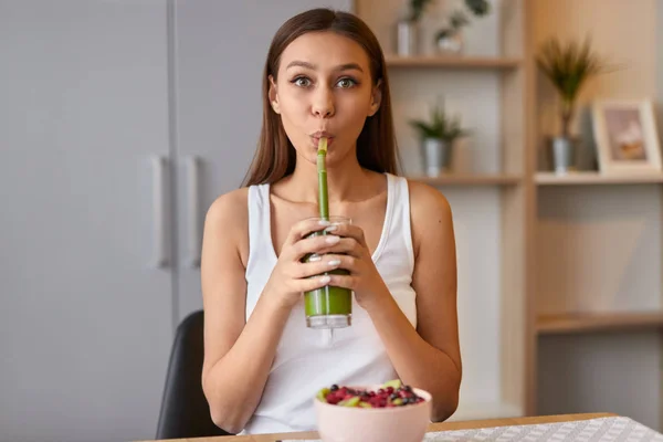 Linda chica bebiendo batido verde para el desayuno — Foto de Stock