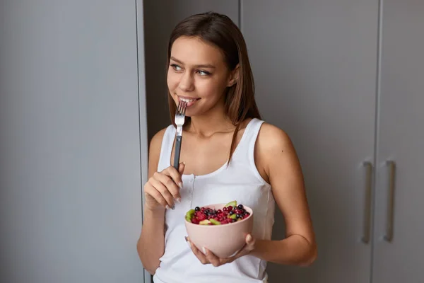 Mujer soñadora comiendo ensalada de frutas — Foto de Stock