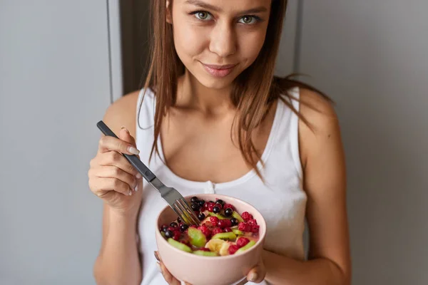 Mujer joven con tazón de ensalada de frutas — Foto de Stock