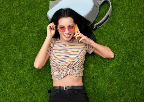 Sorrindo feminino falando no telefone na grama — Fotografia de Stock