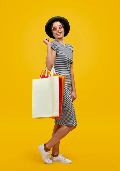 Mujer con bolsas de papel mirando por encima del hombro — Foto de Stock