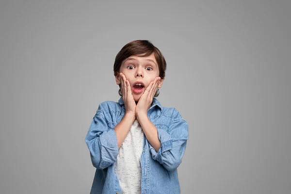 Chockad pojke med händer nära Kinder — Stockfoto